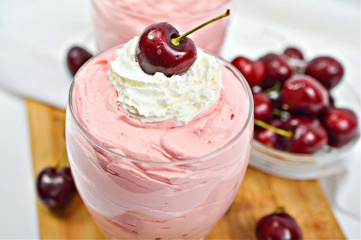 A close up of Keto Cherry Cheesecake Fluff topped with a cherry