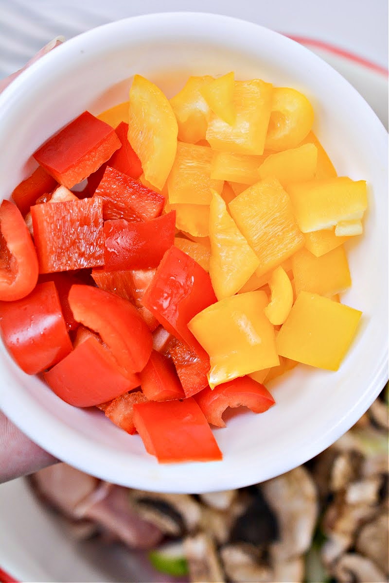 A bowl of chopped red and yellow bell peppers
