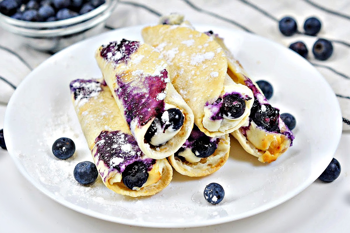 Crispy Keto Blueberry Cream Cheese Roll-Ups on a round white plate