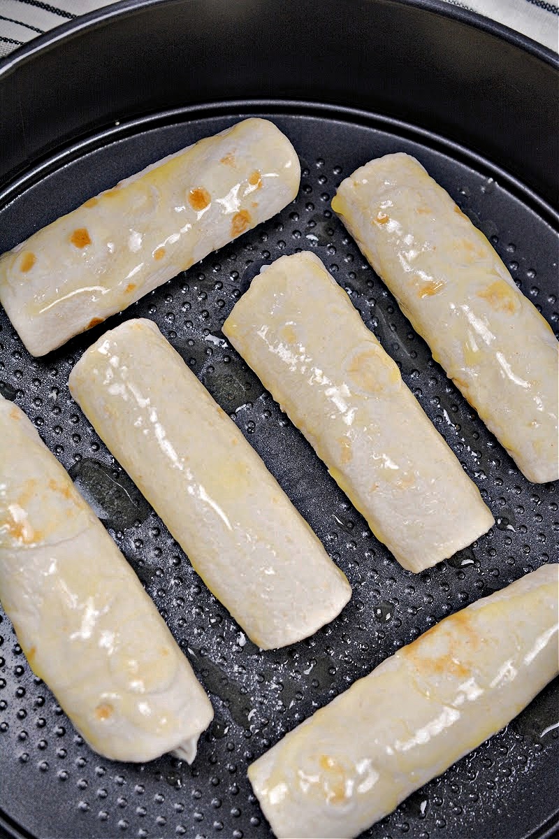 Unbaked Crispy Keto Blueberry Cream Cheese Roll-Ups in the air fryer basket