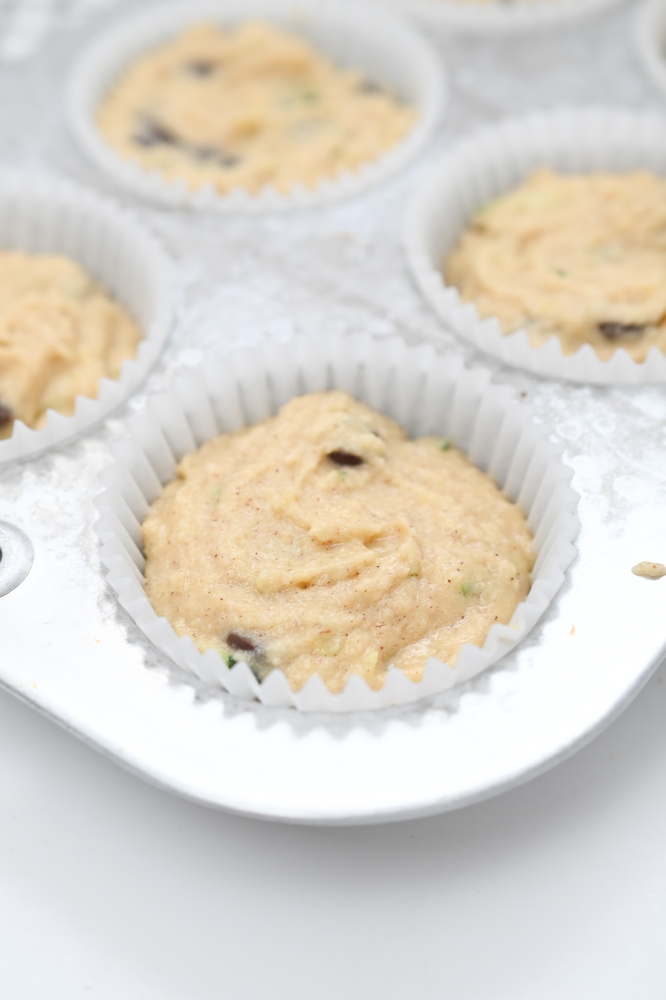 Unbaked muffin batter in a muffin tin