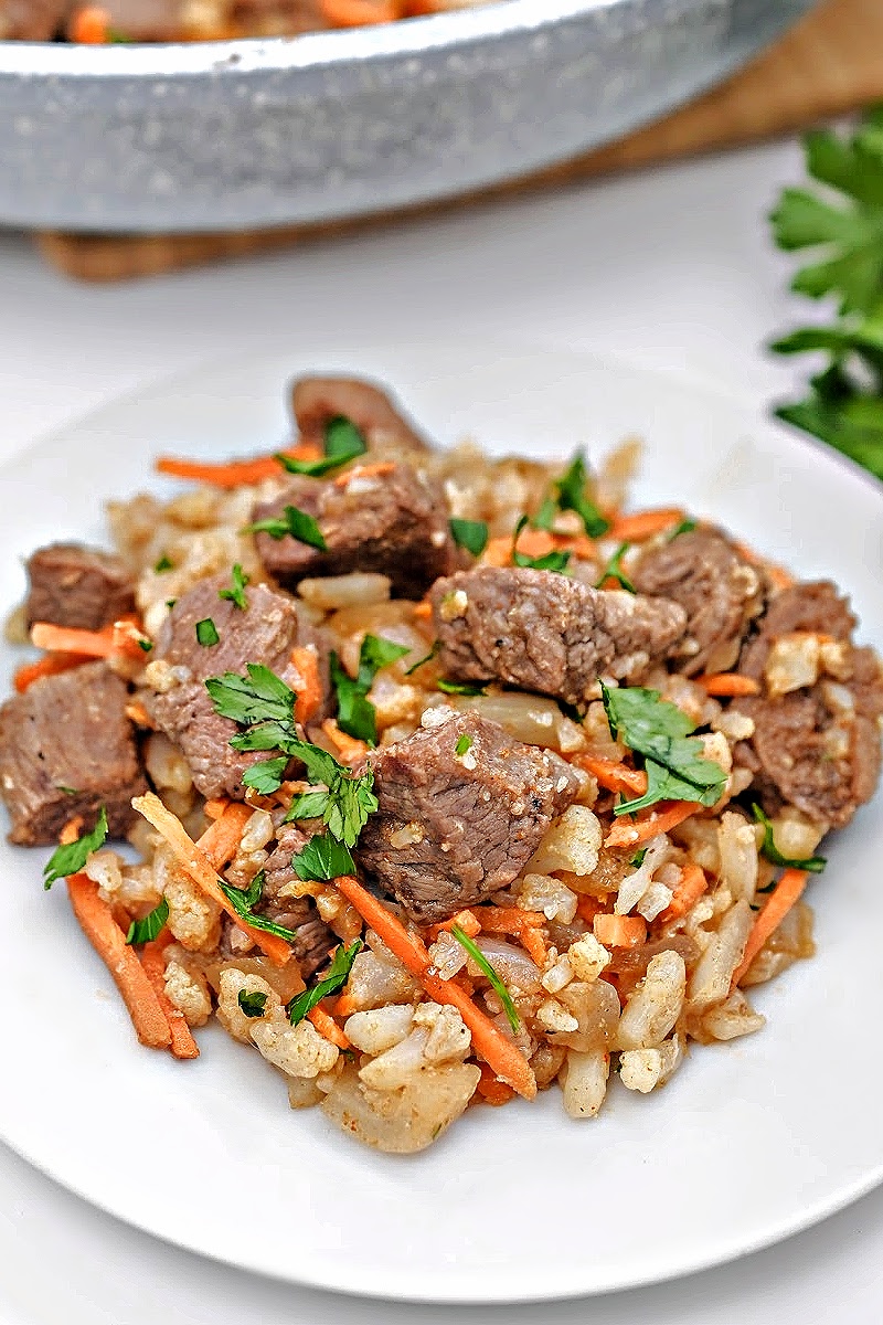 Low-Carb Beef Cauliflower Rice Pilaf on a round white plate