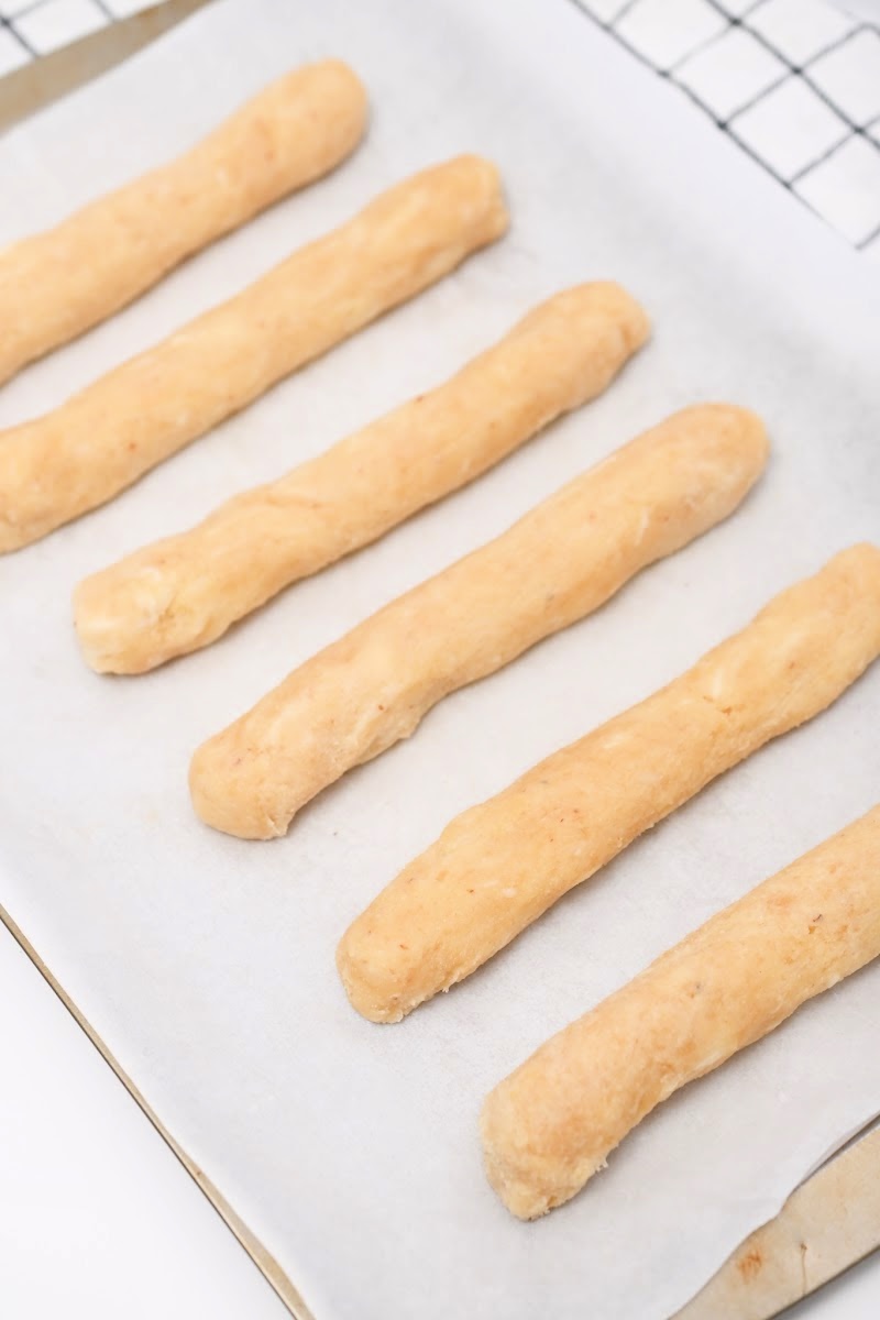 Unbaked Breadsticks On A Baking Sheet