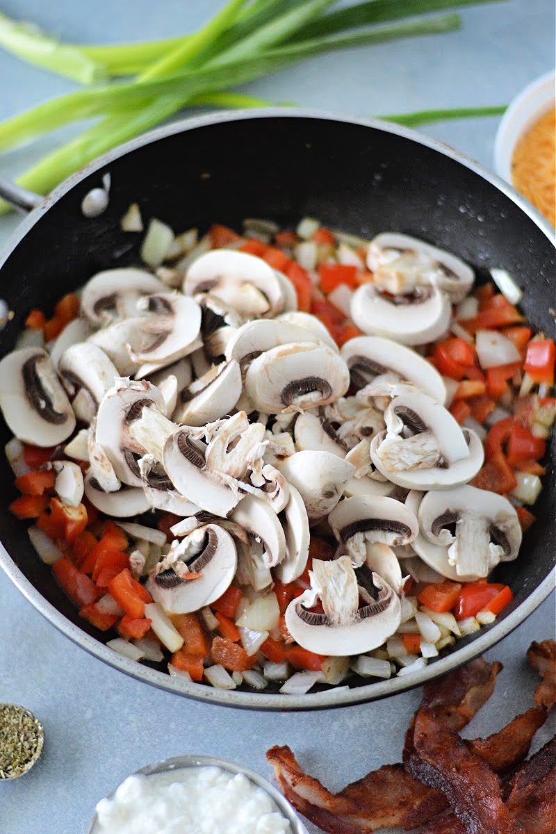 Adding raw veggies to the skillet.