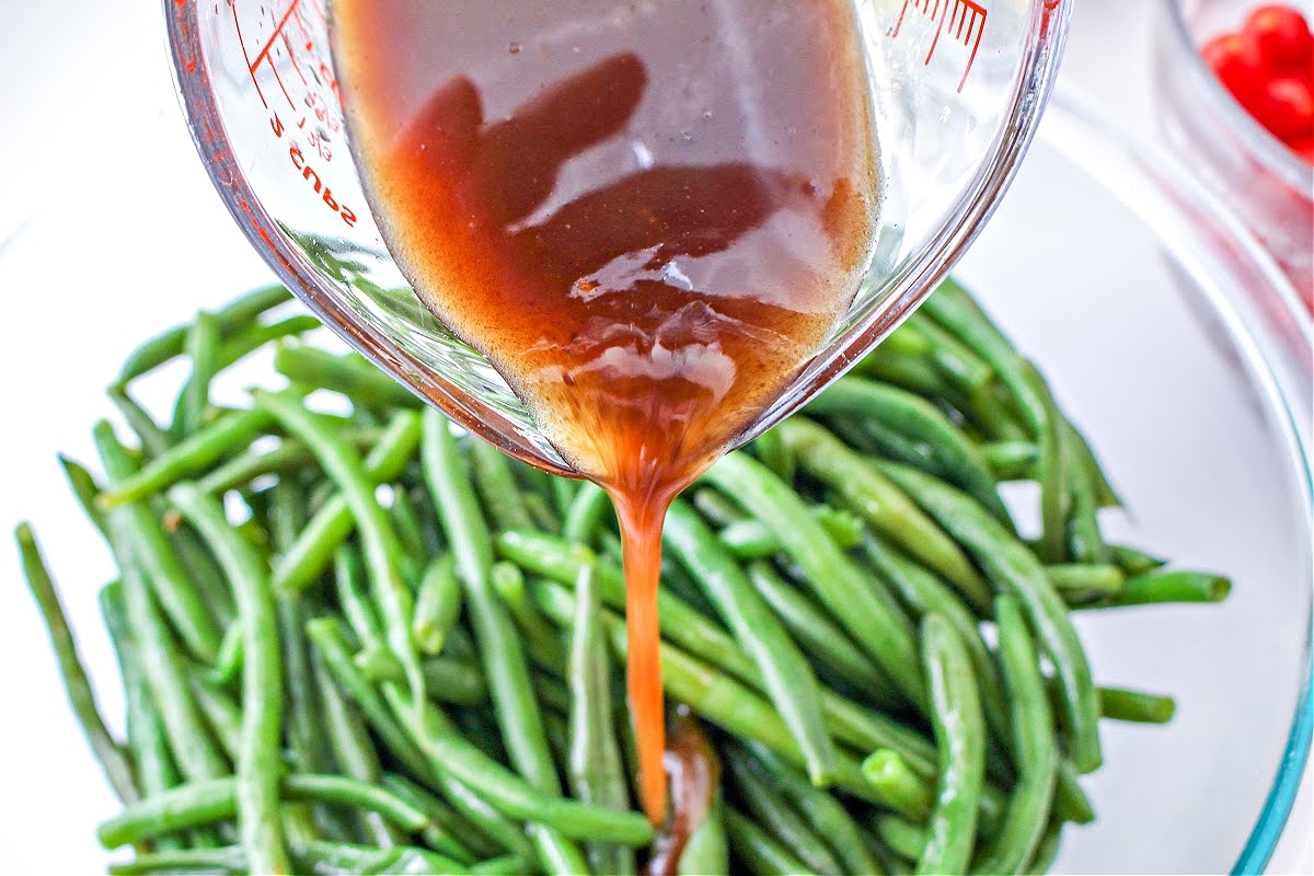 Pouring the balsamic vinegar on the green beans.