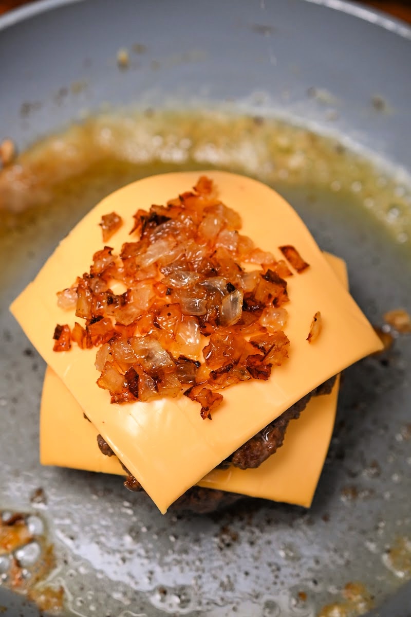 Adding onions on top of the cheese