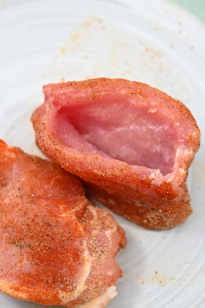 Slicing pork chops in half to stuff them