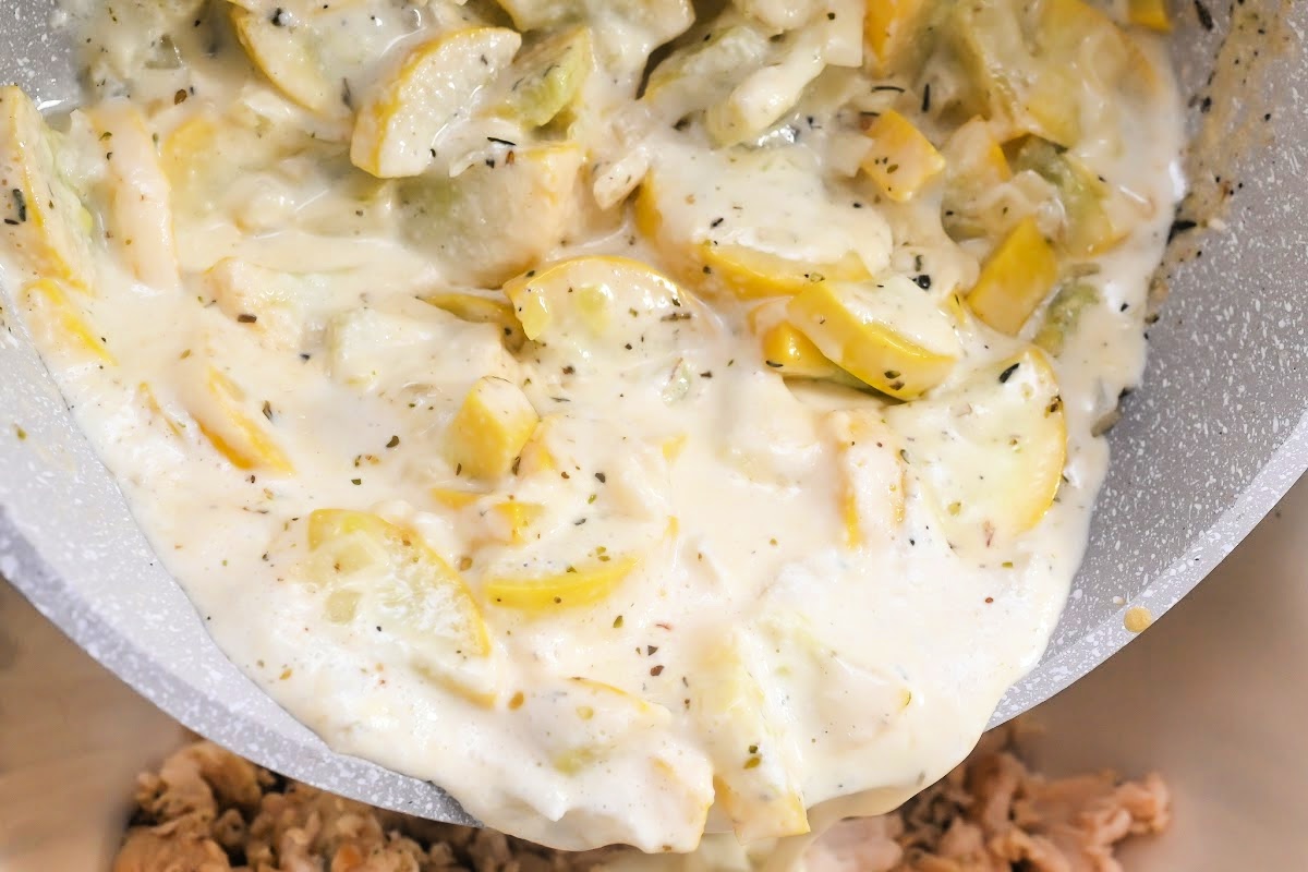 Pouring the creamy squash mixture on top of the chicken