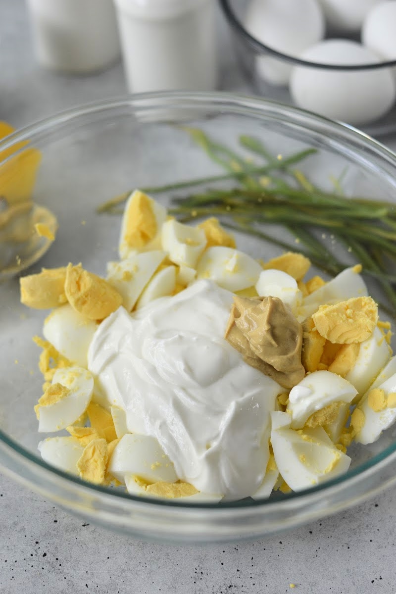 Adding mayo and mustard to egg salad