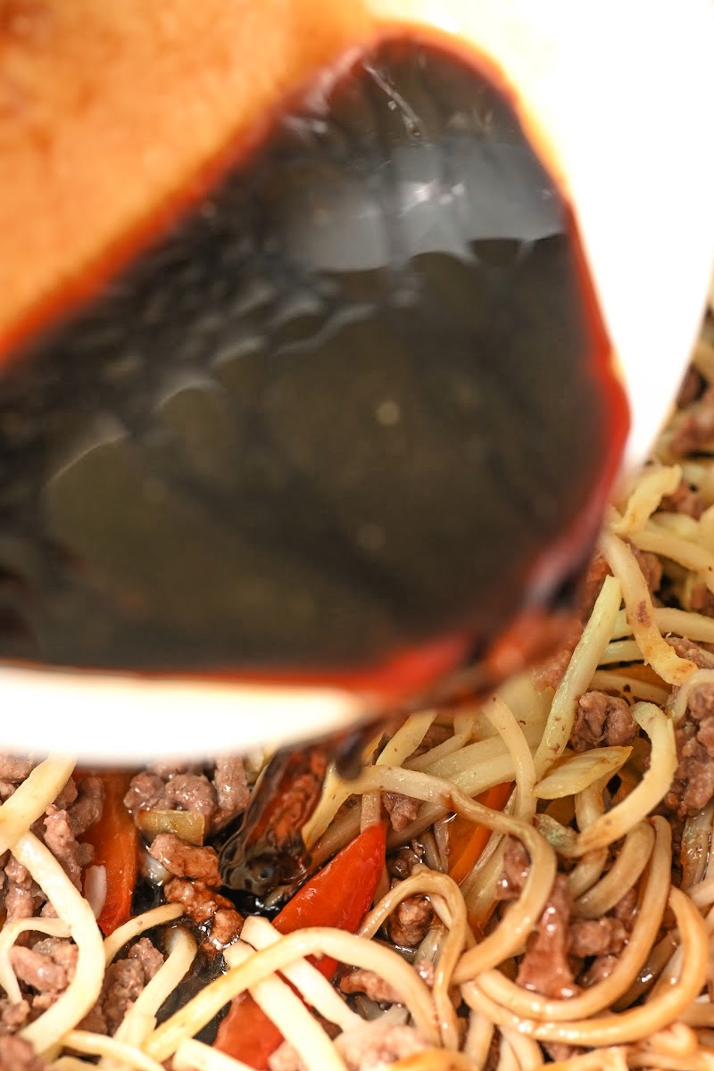 Adding sauce to the noodles