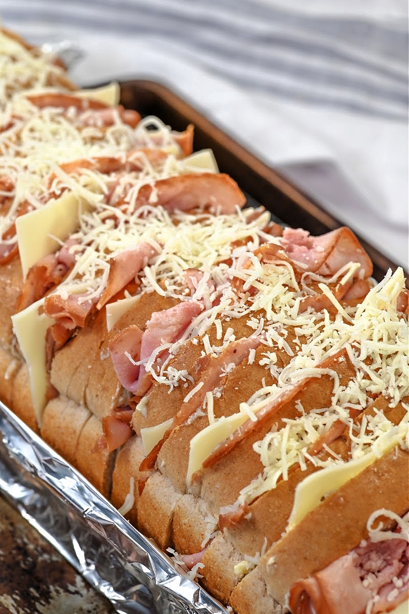 Sprinkling cheese on top of the sandwiches