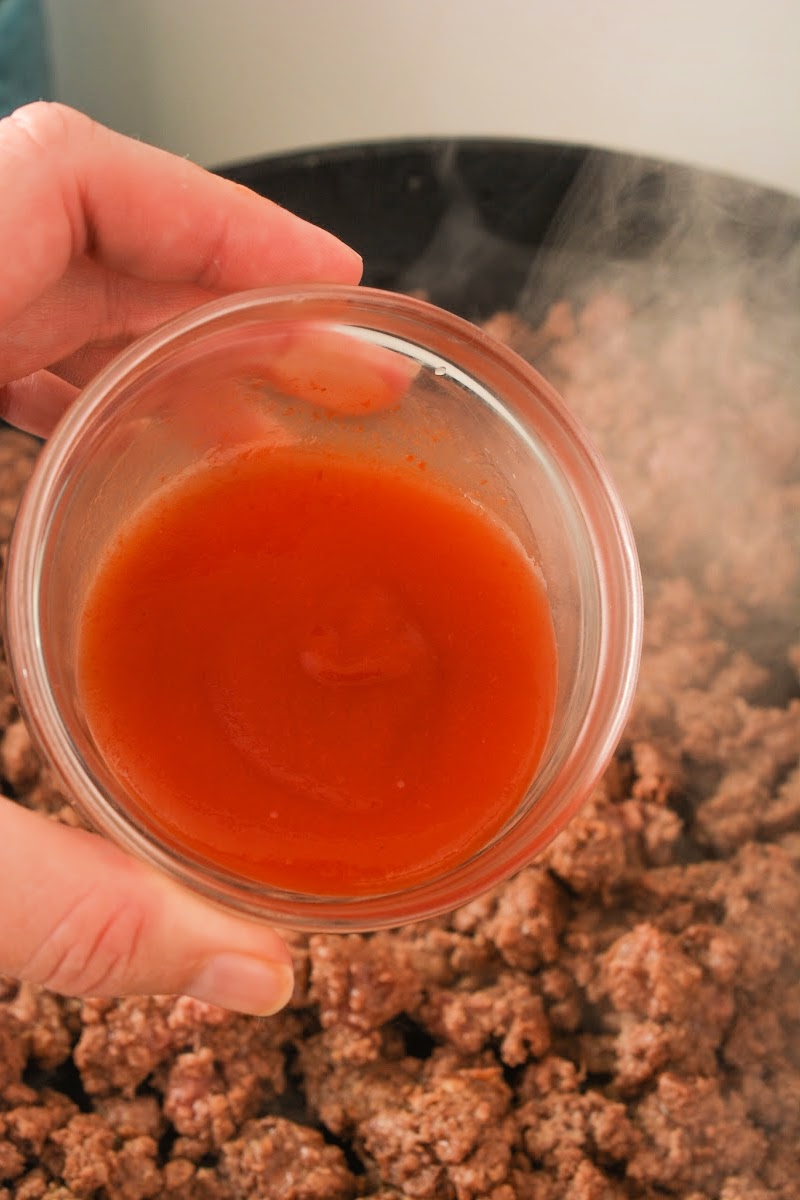 Stirring sugar-free ketchup into the ground beef