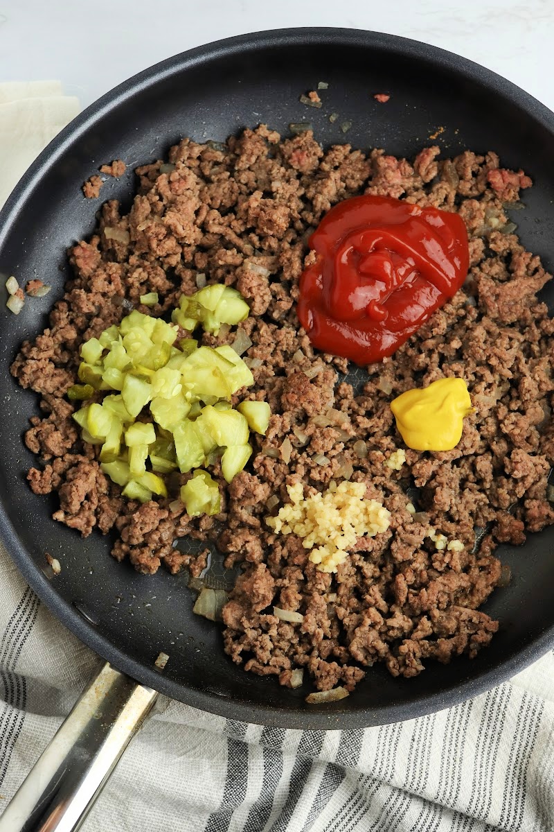 Mixing pickles and ketchup with the ground beef