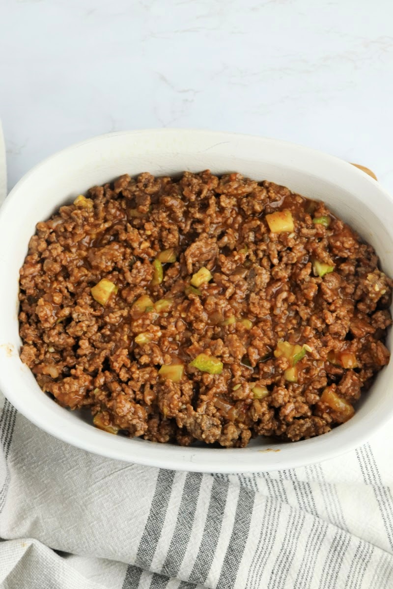 Putting ground beef in the casserole dish