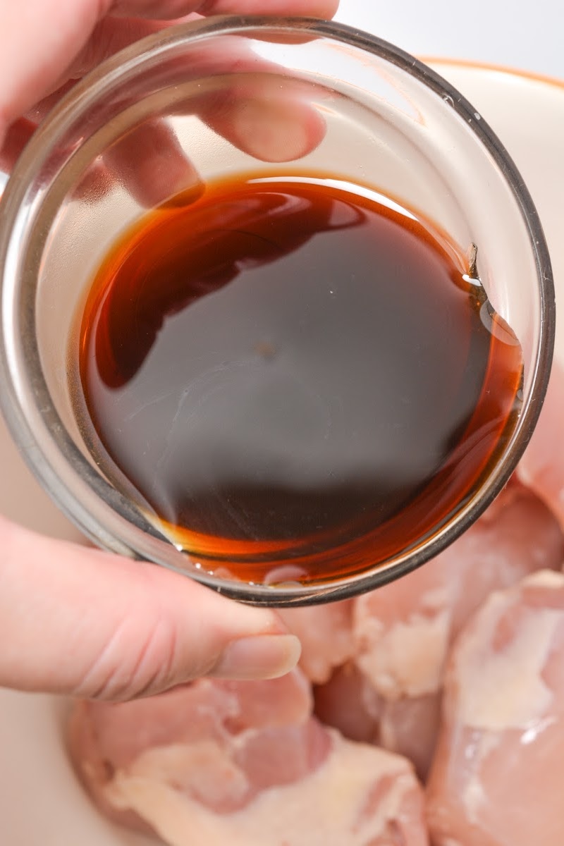 Adding marinade to the chicken thighs