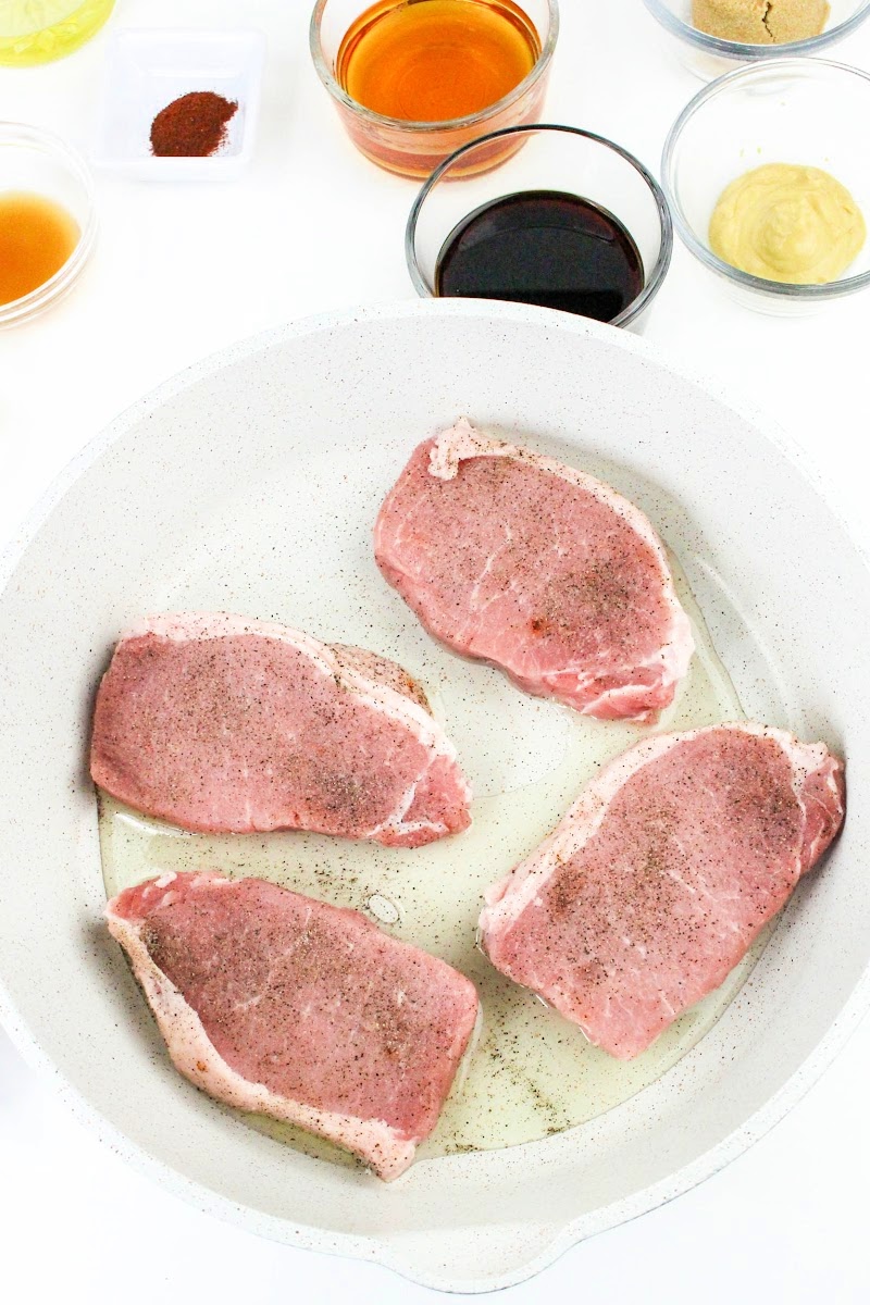 Raw pork chops in a skillet