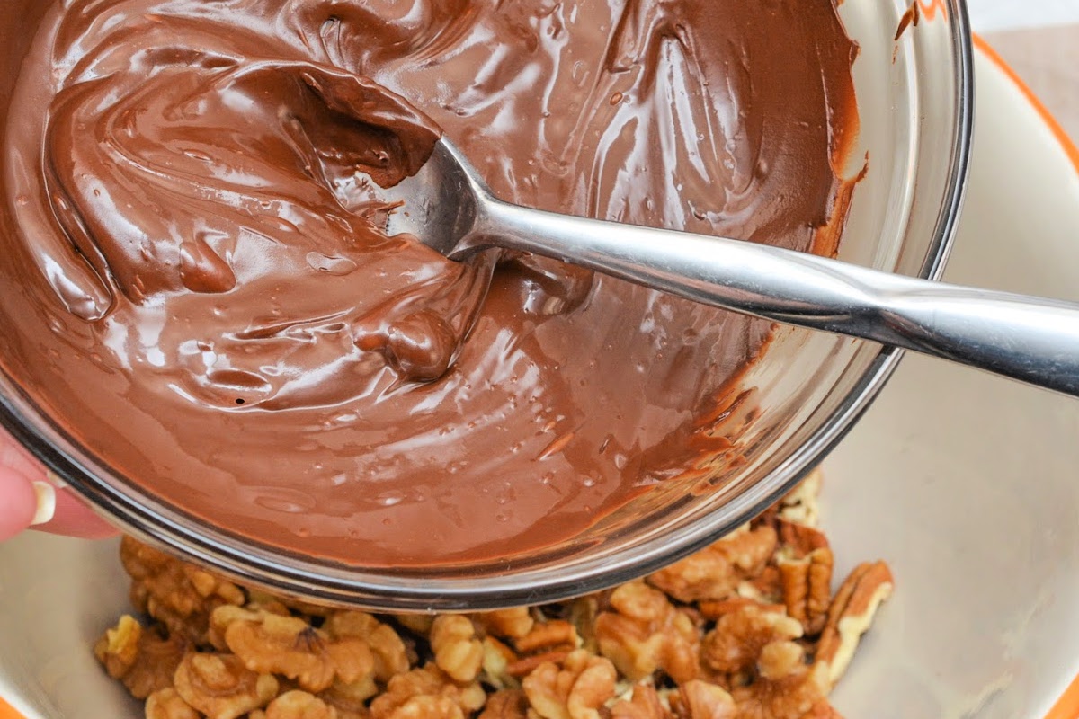 Adding melted chocolate to the nuts