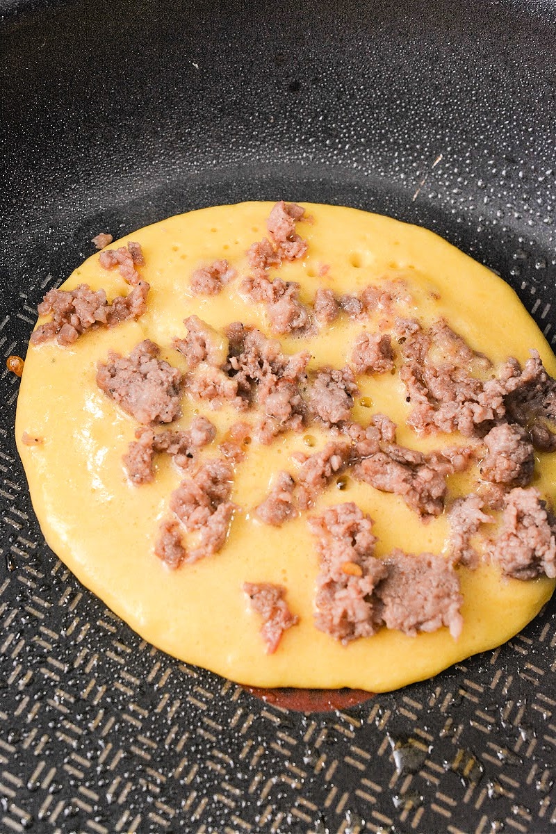 Adding sausage to the pancake batter