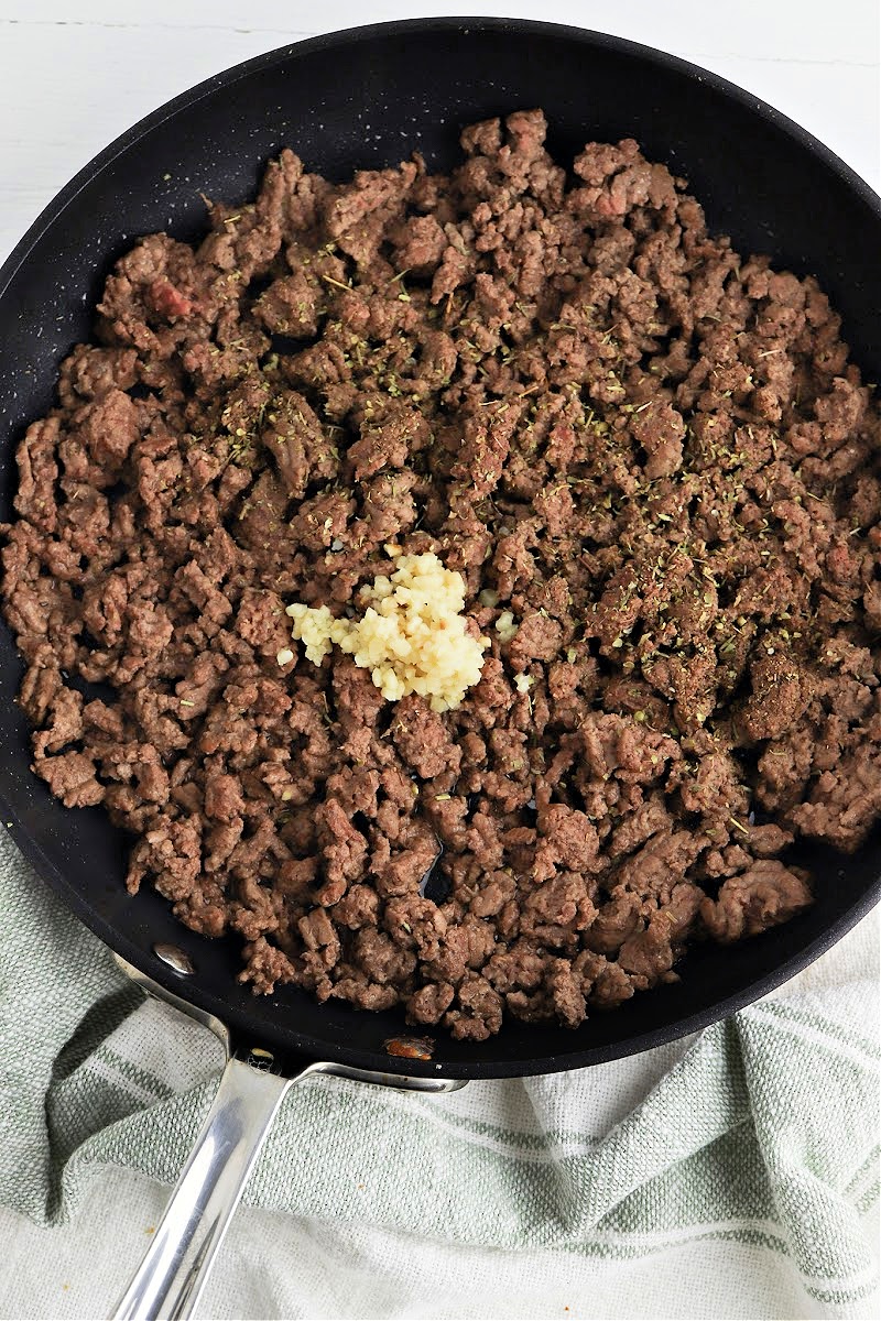 Adding garlic and spices to the ground beef