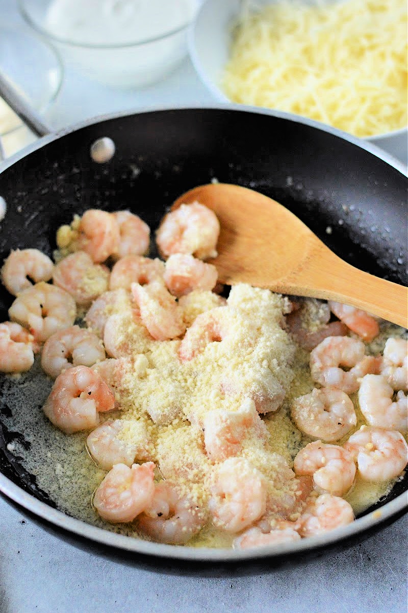 Adding parmesan cheese to the shrimp