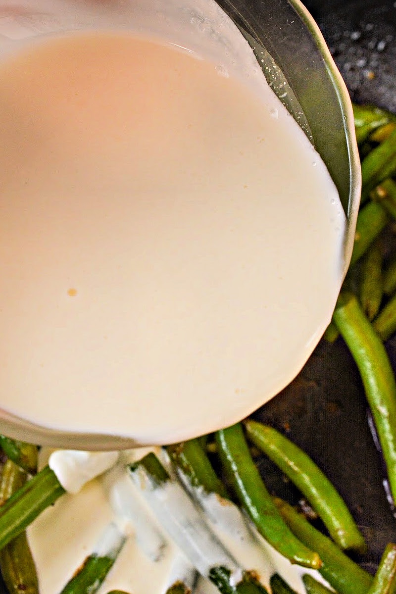 Pouring cream onto the green beans