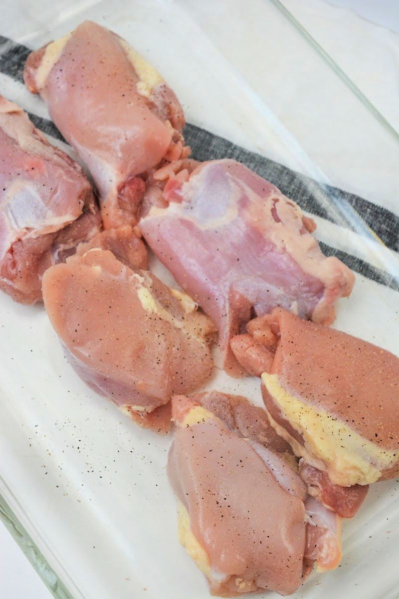 Adding spices to the raw chicken thighs